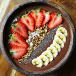 - 1 cup frozen strawberries - 1 banana, sliced and frozen - 1 cup almond milk (or any milk of your choice) - 2 tablespoons unsweetened cocoa powder - 1 tablespoon almond butter (or peanut butter) - 1 tablespoon honey or maple syrup (optional) - Toppings: Fresh strawberries, sliced banana, granola, chia seeds, and shredded coconut - If you don’t have frozen strawberries, use fresh ones. Just add ice to keep it cold. - Any milk works here. Try oat milk or coconut milk for a twist. - If you want a nut-free version, skip almond butter. Use sunflower seed butter instead. - For sweetening, agave syrup can replace honey or maple syrup. - Frozen strawberries: These berries are low in calories and packed with vitamin C. - Banana: Bananas give energy. They are full of potassium and good for digestion. - Almond milk: This milk is low in calories and has healthy fats. It’s also dairy-free. - Cocoa powder: It has antioxidants that help with heart health and mood. - Almond butter: This nut butter adds protein and healthy fats. It keeps you full longer. - Honey or maple syrup: These natural sweeteners add flavor and some vitamins. - Toppings: Fresh fruits add fiber, granola gives crunch, chia seeds are rich in omega-3s, and shredded coconut adds healthy fats. Each ingredient plays a role in making this bowl both tasty and nutritious. To start, gather your ingredients. You need: - 1 cup frozen strawberries - 1 frozen, sliced banana - 1 cup almond milk (or any milk you like) - 2 tablespoons unsweetened cocoa powder - 1 tablespoon almond butter (or peanut butter) - 1 tablespoon honey or maple syrup (optional) 1. Place the frozen strawberries, banana, almond milk, cocoa powder, and almond butter in a blender. 2. If you want it sweeter, add the honey or maple syrup. 3. Blend on high speed until everything is smooth and creamy. 4. Stop the blender and scrape the sides if needed to mix well. 5. Pour the smoothie mixture into a bowl. To get a creamy texture, here are some tips: - Use frozen fruit. It helps make the smoothie thicker. - Start blending at a low speed and then increase to high. - If the mixture is too thick, add a little more almond milk. - Stop to scrape down the sides of the blender for even mixing. Now it's time to make your bowl look great! Here are my suggestions: - Arrange fresh strawberry slices and banana slices on top. - Sprinkle granola for a nice crunch. - Add a few chia seeds for extra nutrition. - Finish with a sprinkle of shredded coconut. Grab a spoon and enjoy your tasty Chocolate Strawberry Smoothie Bowl! To get a smooth and creamy texture, start with frozen fruits. Frozen strawberries and bananas work best. They help make the smoothie thick and rich. Use almond milk or your favorite milk for creaminess. Blend on high until it’s fully mixed. Stop to scrape the sides if needed. This ensures every bit is blended well. Adding almond butter gives it a nice creaminess too. Make your smoothie bowl unique! You can swap the fruits based on what you like. Try mangoes or blueberries instead of strawberries. You can also change the nut butter. Use peanut butter for a different taste. Want more sweetness? Add a bit more honey or maple syrup. You can even mix in some spinach for added nutrition without changing the flavor. Toppings make your bowl look great and add crunch. Arrange fresh strawberries and banana slices on top. Use granola for a nice crunch. Sprinkle chia seeds for a health boost. Shredded coconut adds a tropical touch. Place each topping in sections. This makes your bowl colorful and fun to eat. Remember, how you arrange the toppings can make it more appealing! {{image_2}} You can use different types of milk in this recipe. Almond milk is great, but you can try oat milk, coconut milk, or regular cow's milk. Each milk brings its own taste and creaminess. Oat milk adds a nice sweetness. Coconut milk gives a rich, creamy texture. Cow's milk can make it extra smooth and filling. To boost protein, consider adding protein powder. Use whey, casein, or plant-based protein. You can also add Greek yogurt or cottage cheese for a creamy texture. These options help keep you full and support muscle growth. A scoop of nut butter also adds protein and good fats. While strawberries are delicious, feel free to mix in other fruits. Blueberries, raspberries, or even mango can make tasty swaps. Each fruit has its unique flavor and health benefits. For a tropical twist, try adding pineapple or banana for extra sweetness. If you have leftovers of your Chocolate Strawberry Smoothie Bowl, store them right. Use an airtight container. This keeps the bowl fresh. Place it in the fridge. Your smoothie bowl will stay good for one day. If the smoothie thickens, just add a splash of almond milk before eating. You can freeze your smoothie ingredients for later use. Freeze strawberries and bananas in small bags. This way, they are ready for the next bowl. When you want to make a smoothie, just take out what you need. This helps save time and reduces waste. Meal prep makes mornings easier. Prepare your smoothie bowl ingredients ahead of time. Portion your frozen fruits in bags. You can also mix the dry ingredients, like cocoa powder and almond butter, in a jar. This makes blending quick and easy. Grab a bag, blend, and enjoy! Yes, you can make this smoothie bowl vegan. Use almond milk or any plant-based milk. Replace honey with maple syrup. This way, you keep it tasty and vegan-friendly. To make your smoothie bowl thicker, add less almond milk. You can also use more frozen fruit. Try adding avocado for creaminess without changing the taste. Blending on low speed can help keep it thick. Great toppings include fresh strawberry slices, banana, granola, chia seeds, and shredded coconut. You can also try nuts or seeds for crunch. Chocolate chips can add an extra treat. Choose what you love! Yes, you can use fresh strawberries. However, the smoothie may be thinner and less cold. If you want a chilled bowl, freeze your fresh strawberries first. This keeps your smoothie bowl nice and icy. A smoothie bowl is best fresh. If you cover it, it can last in the fridge for about one day. After that, it may lose its flavor and texture. Enjoy it right away for the best taste! This blog post covered key ingredients, step-by-step instructions, helpful tips, and variations for smoothie bowls. Every ingredient adds unique nutrition. You can easily customize your bowl to fit your taste. Proper storage helps maintain freshness. Remember, you can adjust ingredients for special diets like vegan. With a few easy changes, you can create a perfect smoothie bowl every time. Enjoy blending and experimenting with flavors to find your best version!