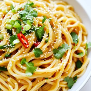 To make garlic chili udon noodles, you will need the following ingredients: - 400g fresh udon noodles - 4 tablespoons sesame oil - 6 cloves garlic, minced - 2 red chilies, sliced (adjust to taste) - 1 tablespoon ginger, grated - 2 tablespoons soy sauce - 1 tablespoon rice vinegar - 1 tablespoon honey or agave syrup - 2 spring onions, chopped - 1/4 cup cilantro or parsley, chopped - Sesame seeds for garnish - Salt and pepper to taste These ingredients come together to create a dish bursting with flavor. Fresh udon noodles are the best choice for this dish. They are soft and chewy. You can find them in many grocery stores or Asian markets. Dried udon noodles can work too, but they need more cooking time. Fresh noodles give a better texture and flavor. If you are short on time, dried noodles are a good option. Just follow the package instructions carefully. You can adjust this recipe to fit different diets. Here are some ideas: - For gluten-free options, use gluten-free udon noodles or rice noodles. - To make it vegan, replace honey with agave syrup. - If you want more protein, add chicken, shrimp, or tofu. - For more veggies, toss in bell peppers or bok choy. Feel free to mix and match these ingredients to suit your tastes. To cook udon noodles, start with a large pot. Fill it with water and add salt. Bring the water to a boil. Add the udon noodles and cook them as per the package instructions, usually about 8-10 minutes. You want them tender but not mushy. Once cooked, drain the noodles in a colander. Remember to save a little pasta water; this will help later. Making the garlic chili sauce is simple. In a small bowl, mix together soy sauce, rice vinegar, and honey or agave syrup. This blend adds a sweet and tangy flavor. Set the sauce aside for now. The next step is key, as the aromas will make your kitchen smell amazing. Heat sesame oil in a large skillet or wok over medium heat. Add minced garlic, sliced red chilies, and grated ginger. Sauté these for 1-2 minutes until they smell fragrant. Be careful not to burn the garlic; burnt garlic turns bitter. Next, add the drained udon noodles to the skillet. Pour the garlic chili sauce over the noodles. Toss gently to combine everything well. If the noodles feel dry, add a bit of the reserved pasta water. This helps create a silky texture. Finally, stir in chopped spring onions and cilantro (or parsley). Season with salt and pepper to taste. Serve hot, garnished with sesame seeds and extra herbs. Enjoy your flavorful meal! You can change how spicy your Garlic Chili Udon Noodles are. Start with two red chilies. If you want more heat, add more chilies. You can also remove the seeds for less spice. If it gets too spicy, add more honey. This will balance the heat. Store leftover udon noodles in an airtight container. Keep them in the fridge. They will last for up to three days. When you’re ready to eat, reheat them gently. Use a pan with a splash of water to keep them moist. You can also use a microwave. Just cover the bowl to trap steam. Serve your noodles with fresh herbs on top. Chopped cilantro or parsley adds color and taste. Pair the noodles with a light salad. A cucumber salad works well. For protein, consider grilled chicken or shrimp on the side. This adds heartiness to your meal. Enjoy the mix of flavors! {{image_2}} You can easily make Garlic Chili Udon Noodles vegetarian or vegan. Just swap honey for agave syrup. Use vegetable broth instead of water for cooking the noodles. This gives them more flavor. You can add extra veggies like bell peppers or snap peas. These add crunch and color. Want to boost your meal? Add protein! Chicken is a great choice. Cook it in the skillet before adding garlic and chilies. Shrimp also works well; just sauté it until pink. For a vegan option, use tofu. Press and cube it first. Sauté until golden brown for a nice texture. Adding more vegetables makes this dish even better. Broccoli florets can add a nice bite. Carrots, sliced thin, bring sweetness. You might also try bok choy or mushrooms. They add a rich, earthy taste. Don't forget to toss in spinach at the end. It wilts down and adds nutrients. After enjoying your garlic chili udon noodles, you might have some left. To store them, let them cool first. Place the noodles in an airtight container. Make sure to cover them well. You can keep them in the fridge for up to three days. If you want, you can store the sauce separately. This helps keep the noodles from getting soggy. To reheat your noodles, use a skillet or a microwave. If you use a skillet, heat it on medium-low. Add a splash of water or oil to help steam the noodles. Stir gently until they are warm. If you use a microwave, place the noodles in a bowl. Cover it with a damp paper towel to keep moisture. Heat in short bursts, stirring in between, until warm. This keeps the flavors fresh and tasty. Freezing garlic chili udon noodles is a great option for longer storage. Allow the noodles to cool completely. Portion them into freezer-safe bags. Remove as much air as possible before sealing. You can freeze them for up to three months. When you're ready to eat, thaw them overnight in the fridge. Reheat as described above for the best results. This way, you can enjoy your favorite dish anytime! Udon noodles are made from wheat flour, water, and salt. They are thick and chewy. This texture makes them perfect for soaking up sauces. Fresh udon is soft and tender. Dried udon can be found in stores too. Both types work well in recipes. Yes, you can make Garlic Chili Udon Noodles ahead of time. Cook the noodles and let them cool. Store them in an airtight container in the fridge. Make the sauce separately and mix it when ready to serve. This saves time and still tastes great. To make this recipe gluten-free, use gluten-free udon noodles. Look for alternatives made from rice or other gluten-free grains. Check the soy sauce too. Use tamari or a gluten-free soy sauce. This way, you can enjoy the dish without gluten. You now know how to make Garlic Chili Udon Noodles. We covered key ingredients, cooking steps, and storage tips. You learned how to adjust spice levels and explore variations for dietary needs. This dish is simple and tasty. Whether you enjoy it fresh or as leftovers, it's a winner. Feel free to get creative with ingredients. Cooking should be fun and rewarding. Try it out and impress your friends! Enjoy your flavorful journey with garlic and chili.