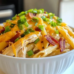 To make Crack Chicken Penne, you will need a mix of tasty and simple ingredients. Here’s what you will gather for this hearty meal: - 12 oz penne pasta - 1 lb boneless, skinless chicken breasts - 1 tablespoon olive oil - 1 packet ranch seasoning mix - 8 oz cream cheese, softened - 1 cup chicken broth - 1 cup shredded cheddar cheese - ½ cup green onions, sliced - 1 cup cooked and crumbled bacon (substitute with plant-based bacon if desired) - Salt and pepper to taste Each ingredient plays a key role in the dish. The penne pasta serves as a perfect base. The chicken breasts bring protein and heartiness. Olive oil helps to cook the chicken, while ranch seasoning adds that special flavor. Cream cheese makes the sauce rich and creamy. Chicken broth enhances the sauce, while cheddar cheese adds extra flavor and creaminess. Green onions give a fresh touch, and bacon adds a delightful crunch. Don’t forget salt and pepper to make everything taste just right. When you gather these ingredients, you set the stage for a meal that is not just filling but also full of flavor. {{ingredient_image_1}} - Start by boiling salted water in a large pot. - Once the water boils, add 12 oz of penne pasta. - Cook the penne until al dente, usually about 8-10 minutes. - Drain the pasta and set it aside for later. - Heat 1 tablespoon of olive oil in a large skillet over medium heat. - Season 1 lb of boneless, skinless chicken breasts with salt and pepper. - Cook the chicken for about 5-7 minutes on each side until fully cooked. - Once cooked, let the chicken rest for a few minutes, then shred it using two forks. - In the same skillet, combine 8 oz of softened cream cheese and 1 packet of ranch seasoning mix. - Stir until creamy and smooth. - Gradually add 1 cup of chicken broth while stirring to combine. - Heat until the sauce is warm and smooth, making sure not to boil. - Add the shredded chicken back into the skillet with the sauce. - Toss in the cooked penne pasta and stir until well coated in the sauce. - Mix in 1 cup of shredded cheddar cheese until melted and creamy. - Fold in 1 cup of cooked and crumbled bacon if you desire. - Top the dish with ½ cup of sliced green onions for a fresh taste. - Adjust seasoning with salt and pepper to your liking. - Serve the Crack Chicken Penne in attractive bowls, garnished with more cheese and green onions. To ensure the chicken is cooked through, use a meat thermometer. The chicken should reach 165°F inside. This will keep your dish safe and tasty. Always let the chicken rest before shredding. This keeps it juicy. For al dente pasta, cook the penne for about 1-2 minutes less than the package says. This means you will have a firm bite, which really enhances the dish. After draining, toss the pasta with a little olive oil. This prevents sticking. To boost flavor, try adding garlic powder or onion powder to the ranch mix. You can also stir in some fresh herbs like parsley or dill. This adds a fresh taste to your meal. If you want it spicier, add red pepper flakes or a dash of hot sauce. For a milder version, simply reduce the ranch mix. You can also use a cream cheese with herbs for a nice twist. For side dishes, a fresh salad pairs well. A simple green salad with a lemon vinaigrette is perfect. You can also serve Crack Chicken Penne with garlic bread or steamed vegetables. Garnish the dish with extra green onions or a sprinkle of more cheese. This makes it look nice and adds some crunch. Serve it in large bowls for a cozy meal feel. Pro Tips Cook Pasta Perfectly: Always cook your pasta al dente to maintain a nice texture that holds up when mixed with the sauce. Season Your Chicken: Don’t skip on seasoning the chicken before cooking; it enhances the overall flavor of the dish. Use Fresh Ingredients: Fresh green onions and quality cheddar cheese make a significant difference in taste and presentation. Adjust Consistency: If the sauce is too thick, add a bit more chicken broth until you reach your desired consistency. {{image_2}} If you want to make this dish plant-based, consider using plant-based bacon. It adds a smoky flavor without meat. Brands like tempeh bacon or coconut bacon work well. You can also use dairy-free cream cheese. Look for brands that taste rich and creamy. They blend well into sauces and keep the dish smooth. You can swap the chicken for turkey or tofu. Turkey gives a leaner taste, while tofu absorbs all the flavors. If you love seafood, shrimp is a tasty choice too. Just cook it until it turns pink. You can also add vegetables like spinach or bell peppers for extra nutrition and color. To change the flavor, try adding different spices or sauces. A sprinkle of paprika or garlic powder can enhance the taste. You can also mix in a bit of hot sauce for a kick. Using assorted cheeses is another fun idea. Blend cheddar with mozzarella or pepper jack for a creamy, zesty flavor. To store leftovers, cool the dish to room temp. Place it in an airtight container. This keeps the flavors fresh and prevents spills. Crack Chicken Penne lasts in the fridge for about 3 to 4 days. Make sure to label the container with the date. You can reheat Crack Chicken Penne in the microwave or on the stove. For the microwave, use a microwave-safe bowl. Heat in 30-second bursts, stirring in between. On the stove, add a splash of chicken broth in a skillet. Heat on low and stir until warm. To keep it creamy, avoid high heat and stir often. To freeze Crack Chicken Penne, let it cool completely. Place it in a freezer-safe bag or container. Squeeze out as much air as possible. It can stay frozen for up to 3 months. When ready to eat, thaw it overnight in the fridge. Reheat using the same methods mentioned above. Add a bit of broth if it seems dry after thawing. Yes, you can make Crack Chicken Penne ahead of time. To do this, prepare the dish fully and let it cool. Store it in an airtight container in the fridge. It will stay fresh for up to three days. When ready to eat, simply reheat it on the stove or in the microwave. Add a splash of chicken broth if the sauce seems thick. Absolutely! Crack Chicken Penne is great for meal prep. You can divide it into individual portions for easy lunches or dinners. Just store each portion in a sealed container. This makes it easy to grab and go. Plus, it tastes just as good reheated. Crack Chicken Penne pairs well with many sides. A simple green salad adds freshness. Garlic bread is a tasty option too. You might also enjoy steamed veggies for a healthy balance. Pair it with a light white wine or iced tea for drinks. Yes, you can easily make Crack Chicken Penne gluten-free. Use gluten-free penne pasta instead of regular pasta. Many brands offer good options. Just check the label to ensure it meets your needs. This way, everyone can enjoy this delicious meal! Crack Chicken Penne blends simple ingredients into a delicious meal. We covered each step, from cooking pasta to mixing in cheese and bacon. Remember to adjust flavors to fit your taste. You can easily customize this dish with substitutions or new proteins. Don’t forget the best practices for cooking and storage. Enjoy this comforting dish with friends or family, and feel free to experiment with your own twists. Cooking can be fun and creative, and Crack Chicken Penne is a great dish to try!